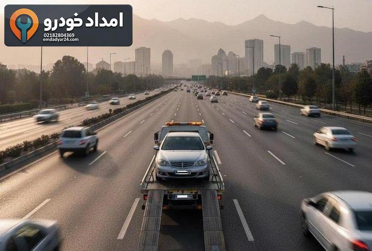 خودروی متوقفشده در شبی بارانی روی بزرگراه تهران و یدککش در حال نزدیک شدن